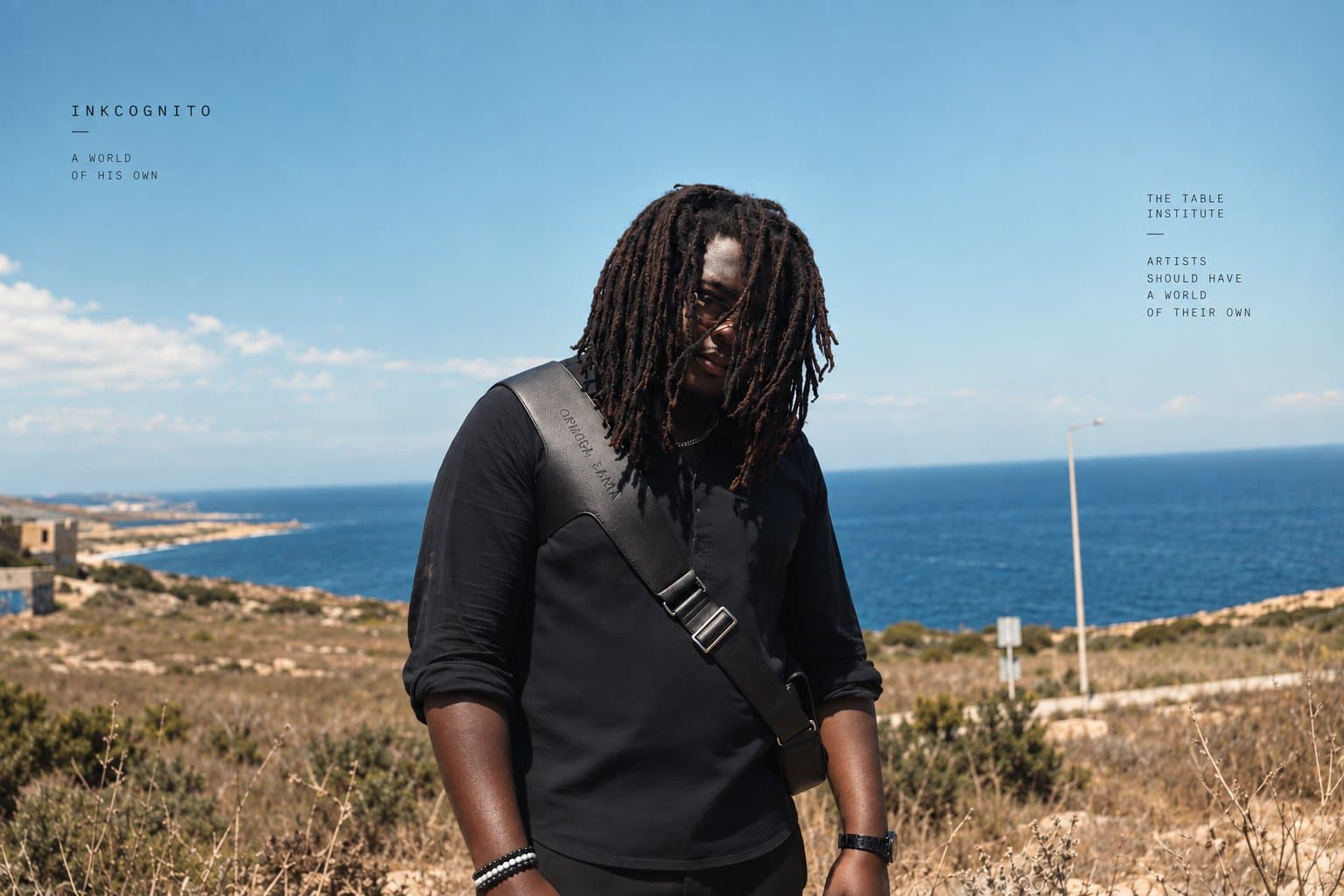 Inkcognito standing outdoors above the sea